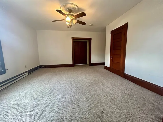 a view of an empty room with a chandelier fan