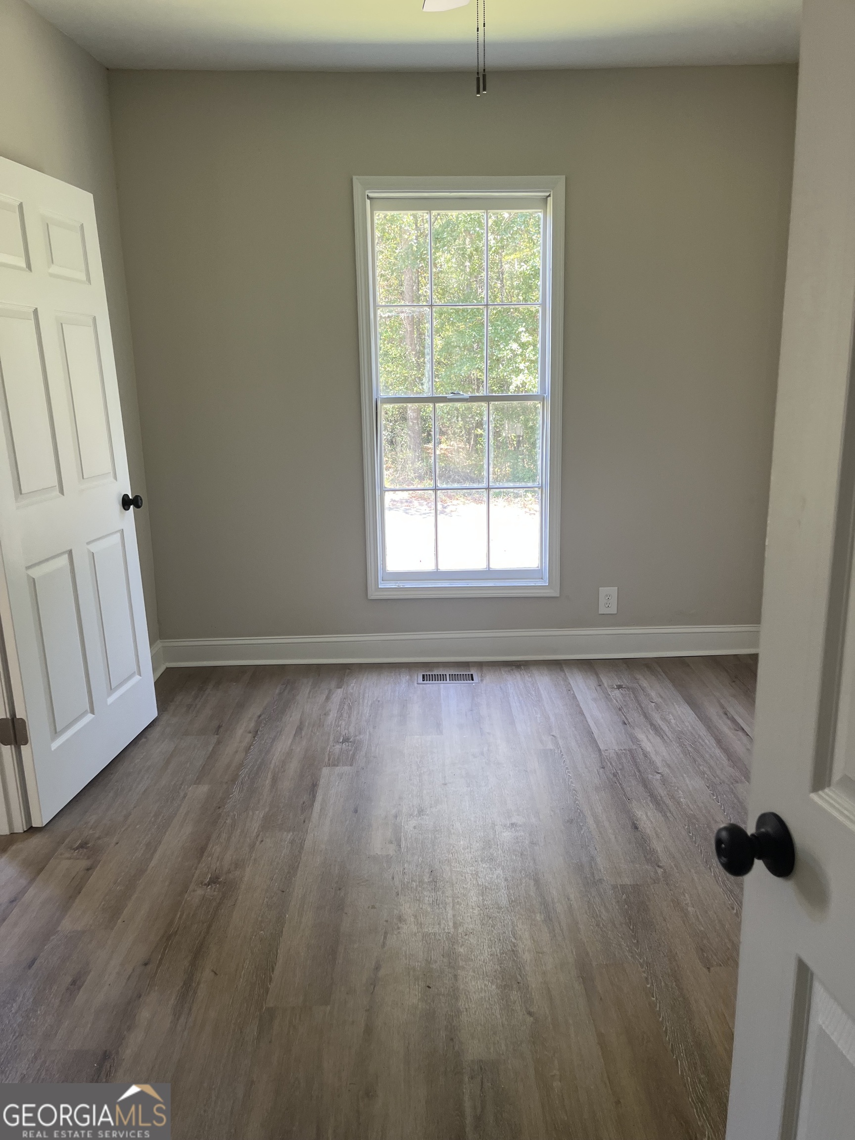 802 J D Parham Drive Manchester, GA 31816 - Photo 16 of 17 an empty room with wooden floor and windows