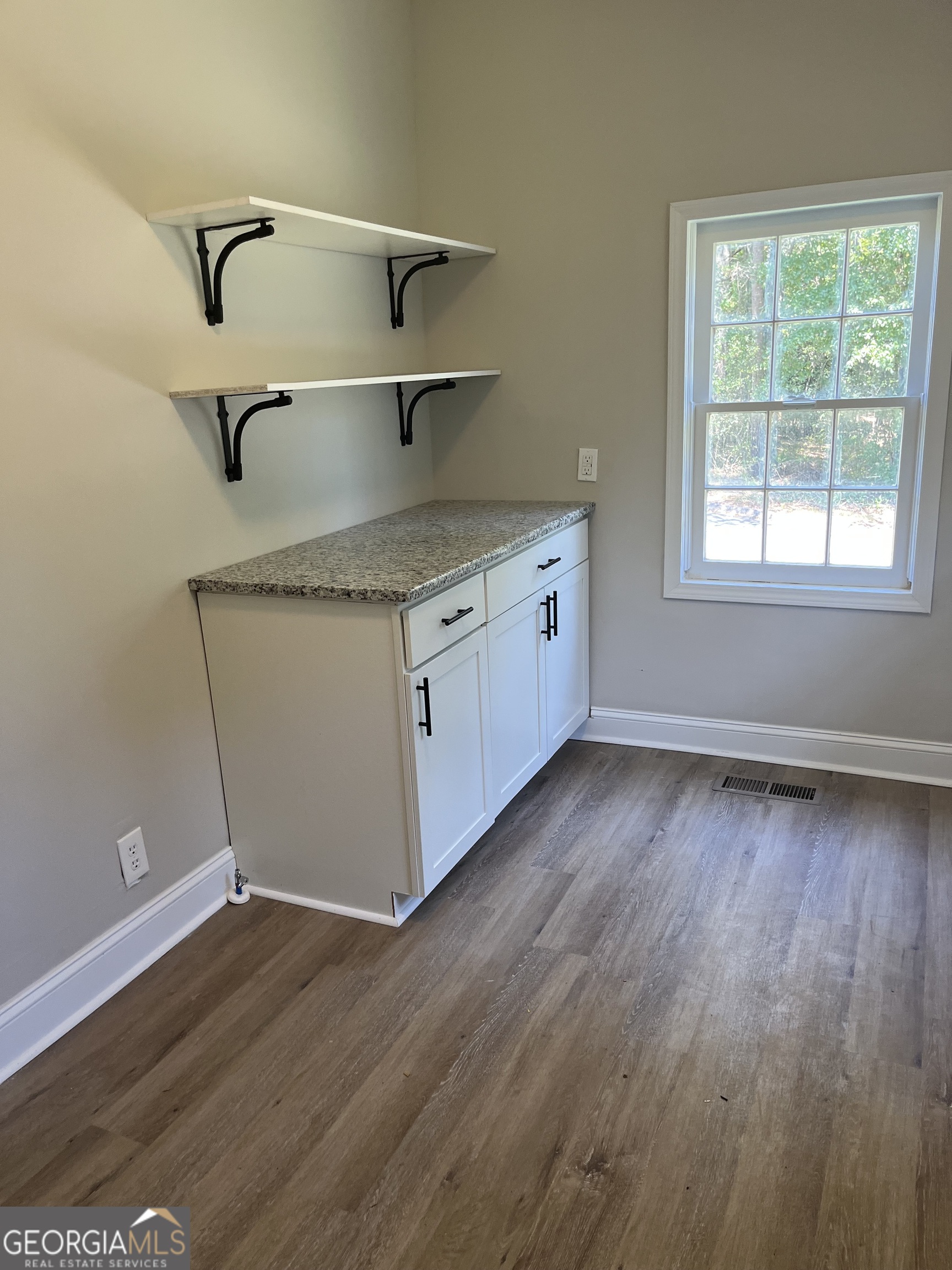 802 J D Parham Drive Manchester, GA 31816 - Photo 9 of 17 a kitchen with granite countertop a sink cabinets and wooden floor