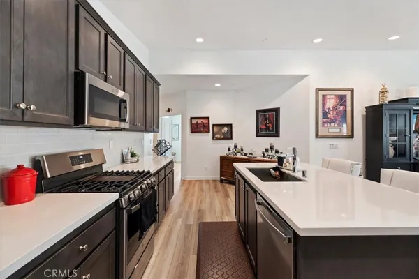 a kitchen that has a sink cabinets and wooden floor