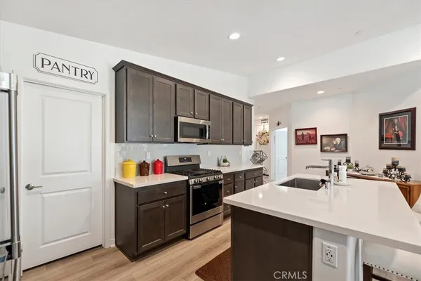a kitchen with stainless steel appliances granite countertop a refrigerator and a stove top oven