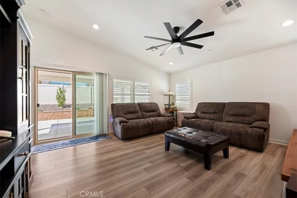 a living room with furniture kitchen view and a window