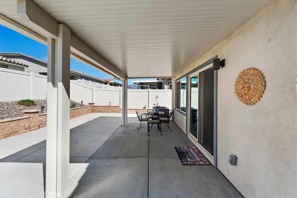 a backyard of a house with table and chairs