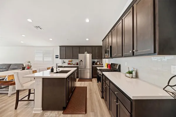 a view of a kitchen with kitchen island stainless steel appliances a stove and center island