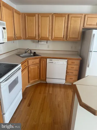 a kitchen with granite countertop a sink a stove and cabinets