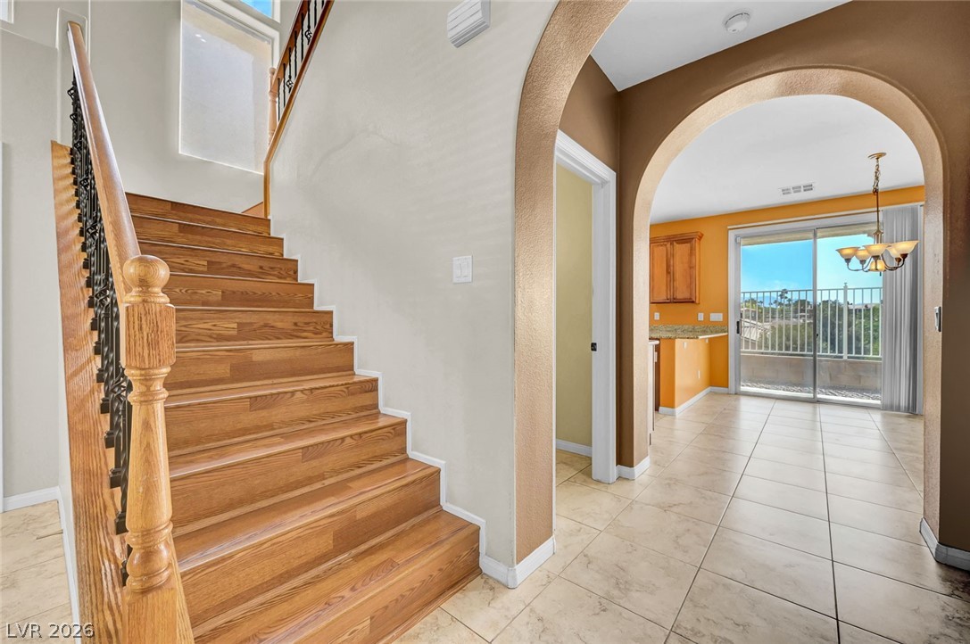 977 Sparkling Light Street Henderson, NV 89052 - Photo 21 of 75 Elegant wooden staircase and arched doorways define this inviting interior space.