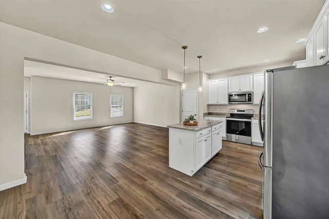 a large kitchen with hardwood floor and a refrigerator