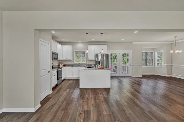a large kitchen with cabinets wooden floor and stainless steel appliances