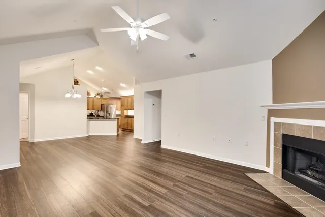 a view of empty room with wooden floor and a fireplace