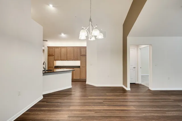 a view of a kitchen with granite countertop wooden floor and a chandelier