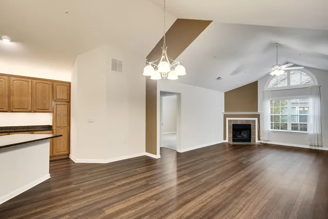 a view of a livingroom with a fireplace wooden floor and chandelier