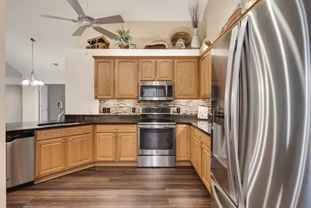 a kitchen with granite countertop a refrigerator and a sink