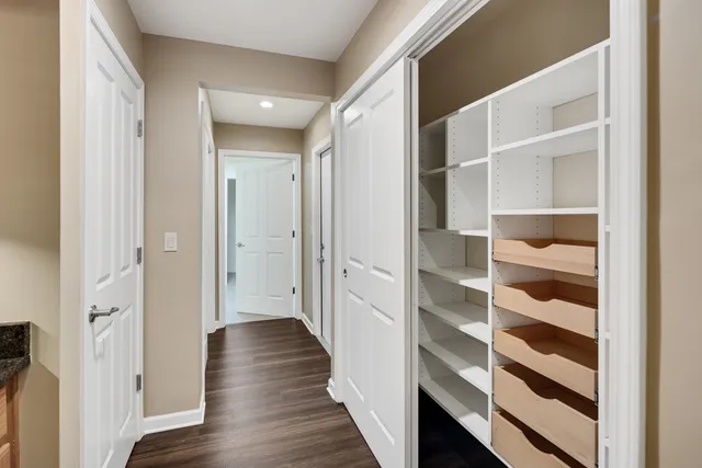 a view of a hallway with wooden floor and closet