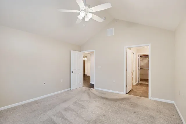an empty room with a ceiling fan and a window