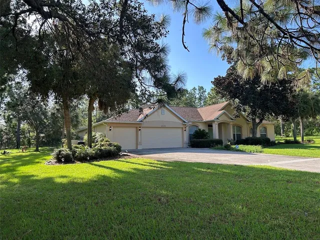 a front view of a house with a yard and trees