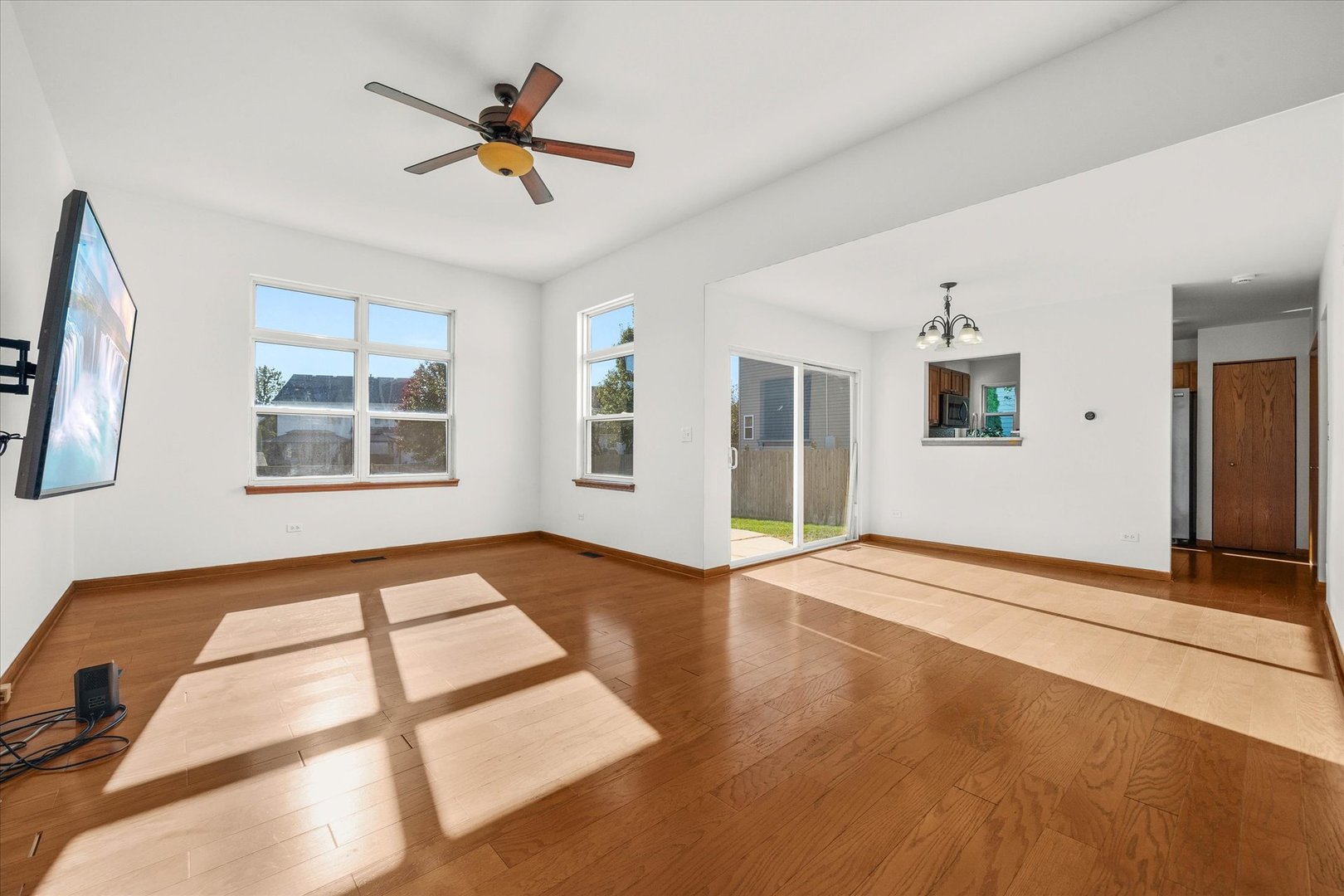 2152 Brayton Place Plainfield, IL 60586 - Photo 6 of 28 a view of an empty room with window and wooden floor