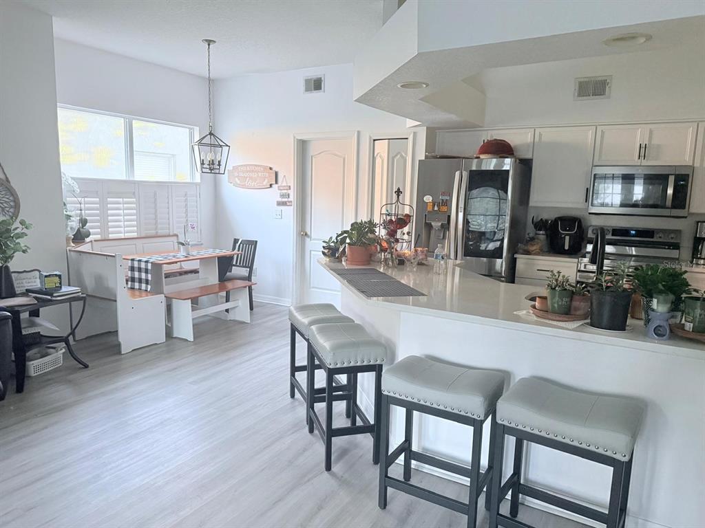 609 Prince Lane Oviedo, FL 32765 - Photo 5 of 20 a dining room with stainless steel appliances kitchen island granite countertop a table chairs and a refrigerator
