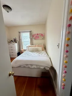 a bedroom with a bed and a painting on the wall