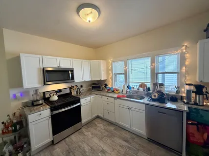 a kitchen with a sink stove top oven and refrigerator