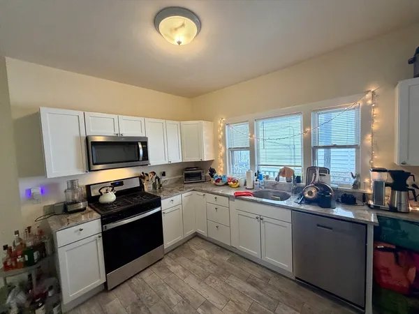 a kitchen with a sink stove top oven and refrigerator