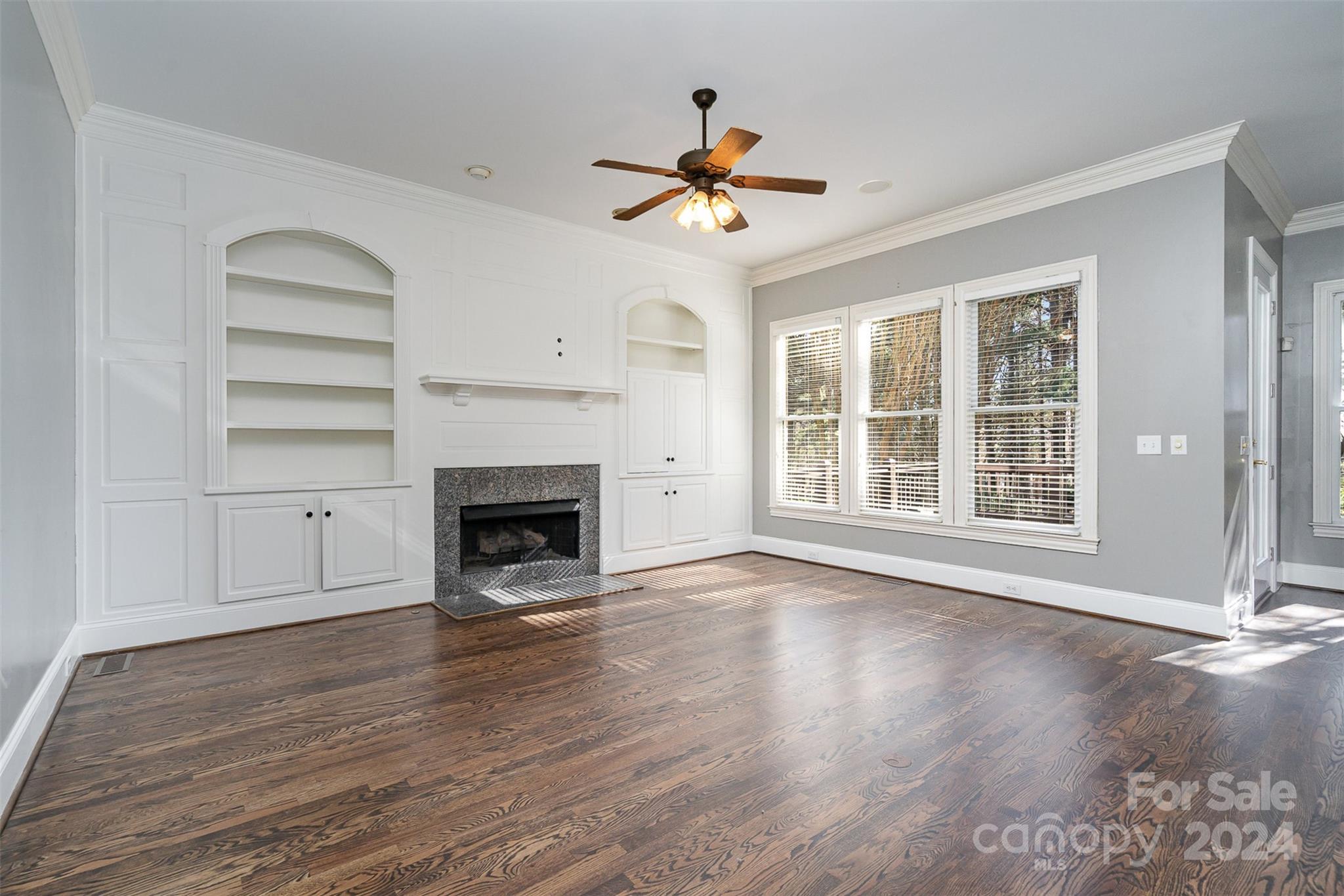 128 Mayfair Road Mooresville, NC 28117 - Photo 8 of 35 a view of a livingroom with a fireplace a ceiling fan and windows