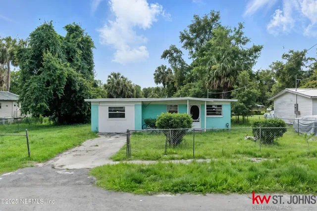 a view of a house with a yard and potted plants