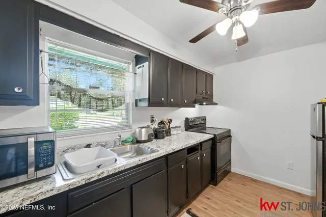 a kitchen with a sink stove and microwave