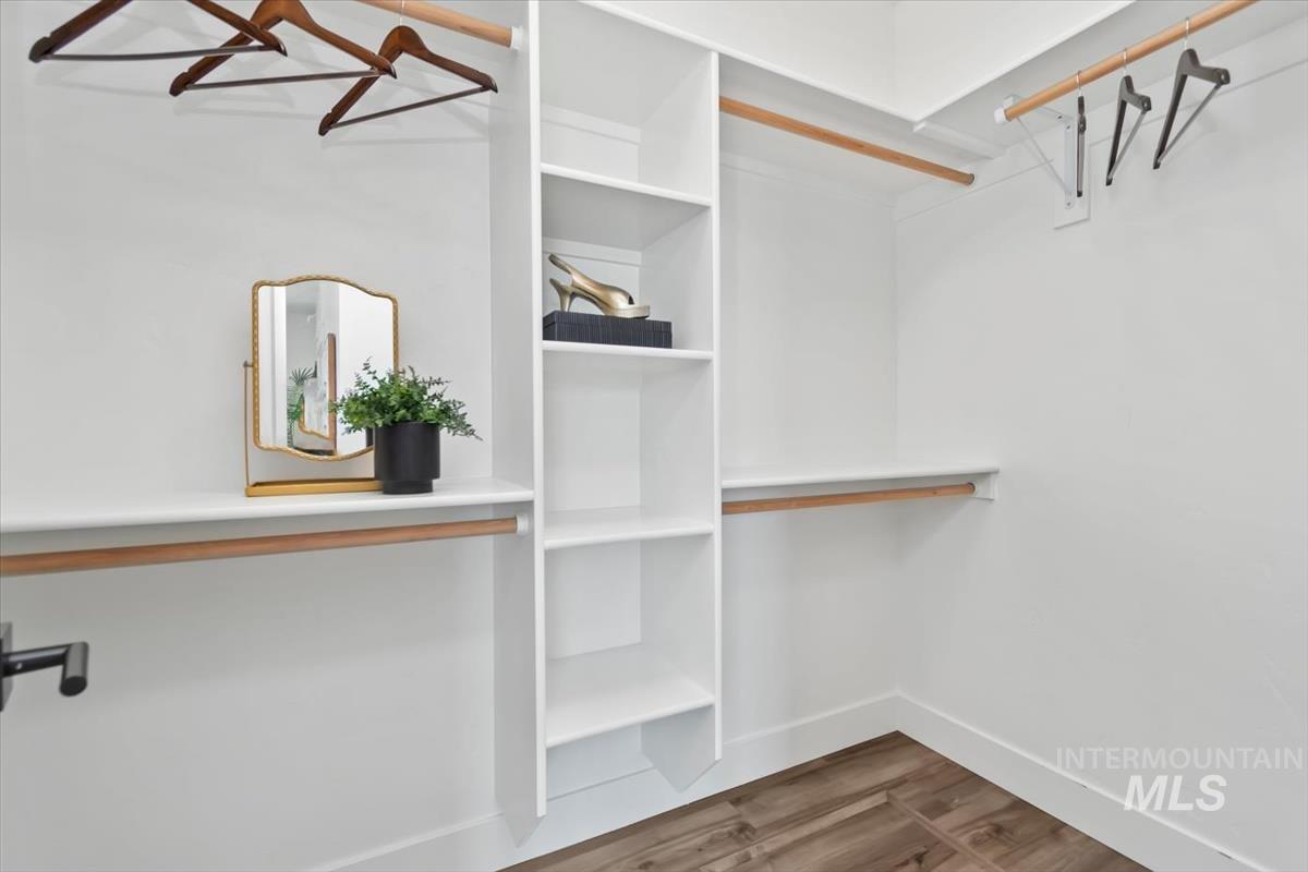 5897 West Riva Capri Street Meridian, ID 83646 - Photo 21 of 50 Closet with integrated shelving, multiple hanging rods, and wood-finish flooring