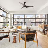 a room with lots of tables a large window and chairs