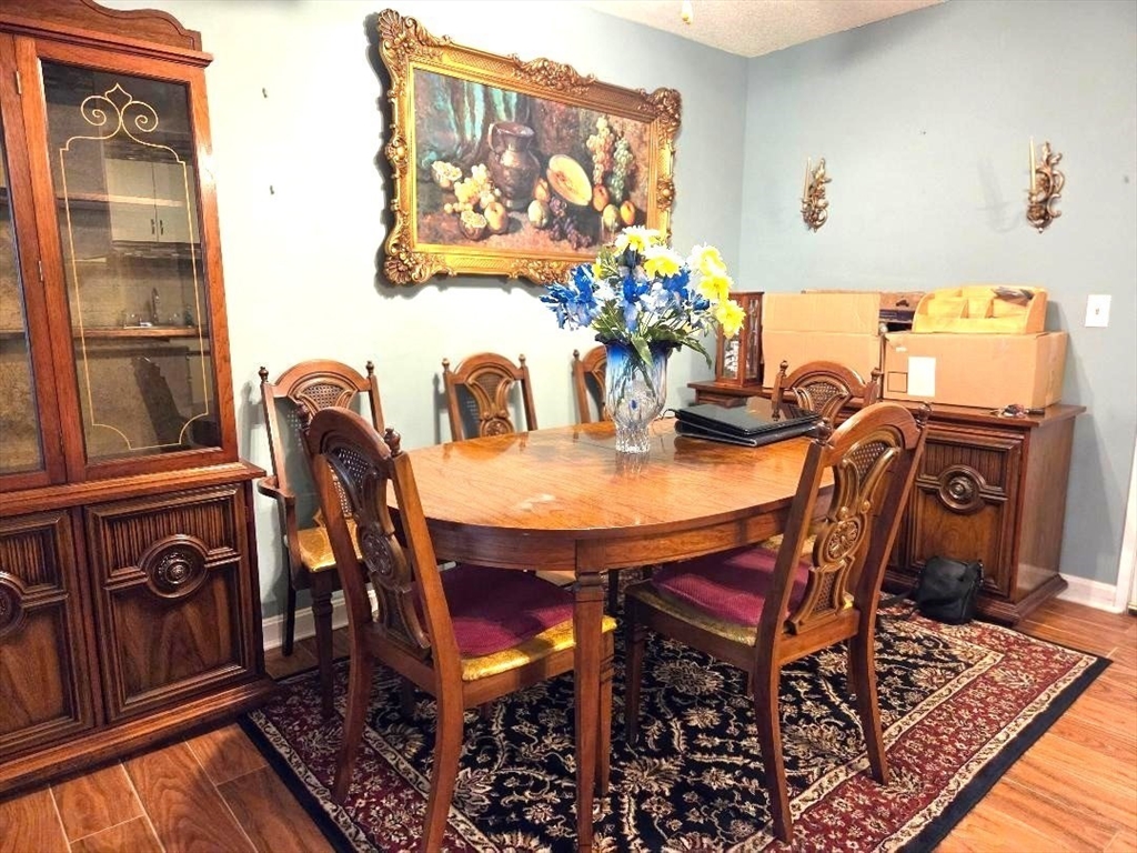 4234 North Main Street, Unit 103 Fall River, MA 02720 - Photo 3 of 10 a dining room with furniture potted plants and wooden floor