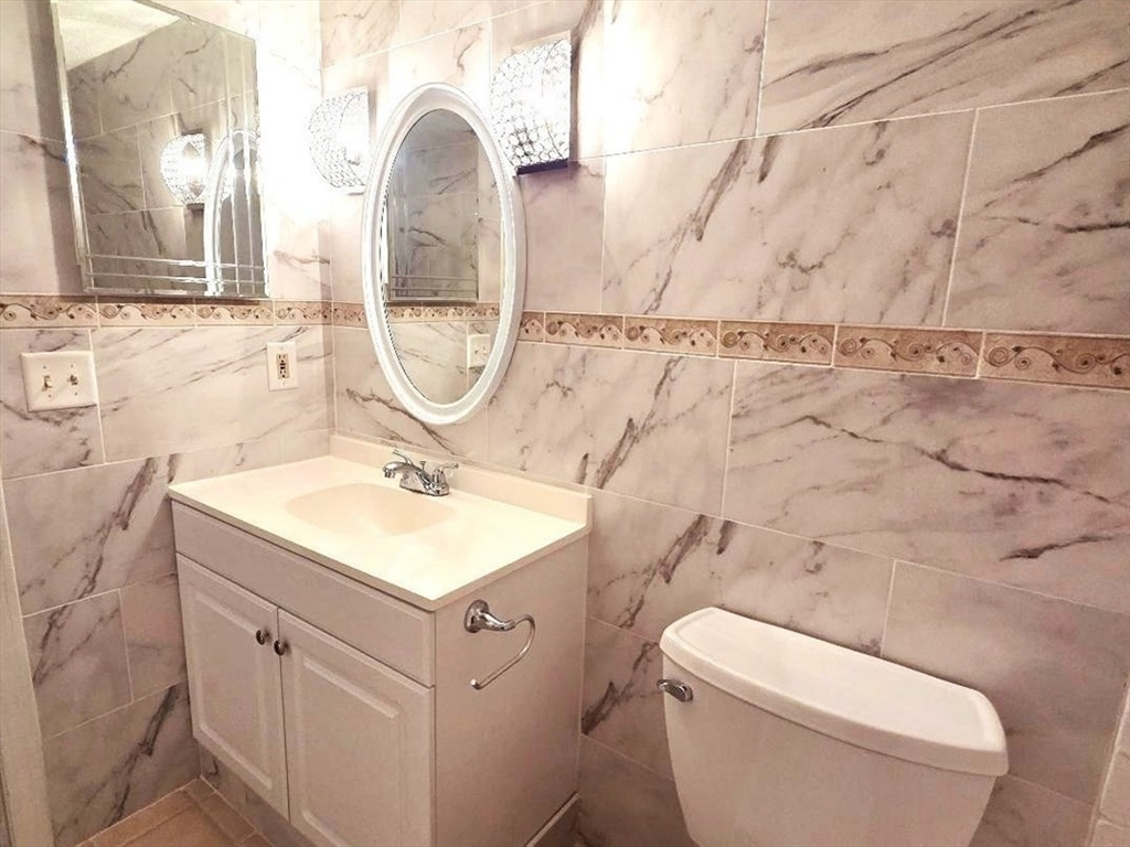 4234 North Main Street, Unit 103 Fall River, MA 02720 - Photo 9 of 10 a bathroom with a sink toilet and a mirror