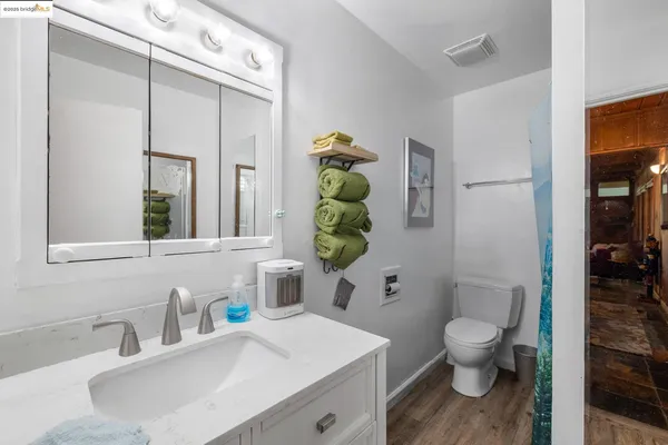 a bathroom with a sink a toilet and shower