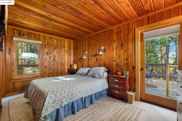 a bedroom with a bed and a dresser next to a window