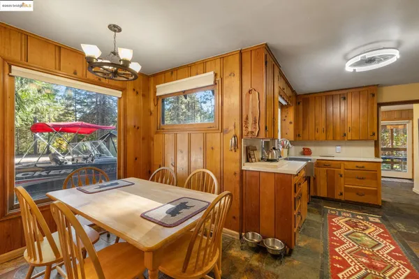 a kitchen with stainless steel appliances granite countertop a stove a sink dishwasher and a dining table with wooden floor