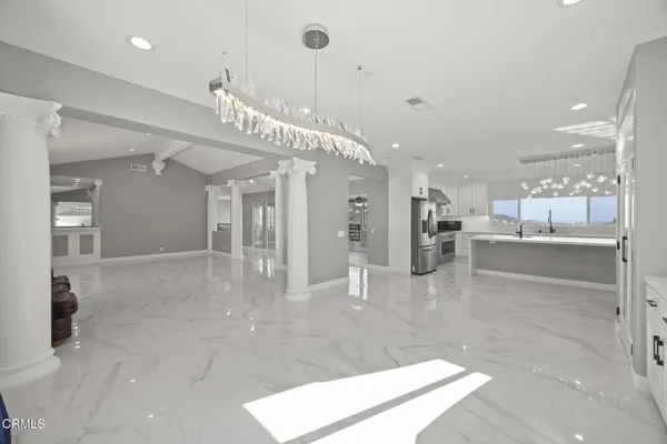 a view of an empty room with a fireplace and a window