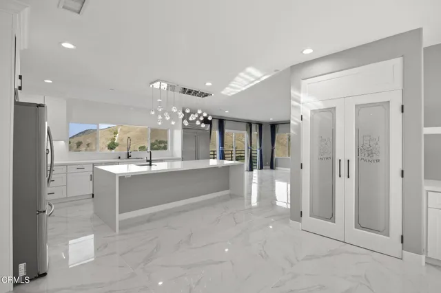 a view of a living room a large window and kitchen view