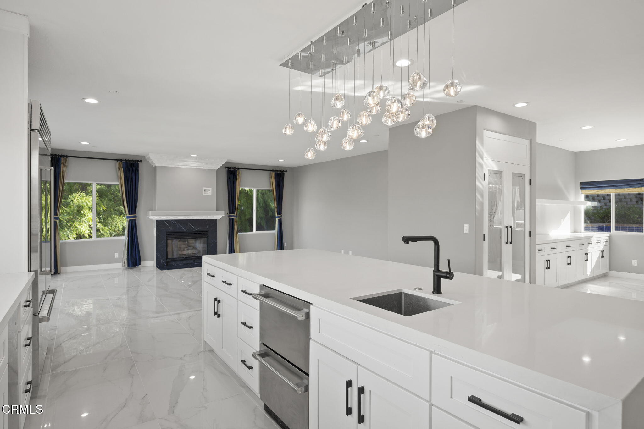 40 Saddlebow Road Bell Canyon, CA 91307 - Photo 26 of 70 a large white kitchen with a sink dishwasher a stove and a dining table with wooden floor