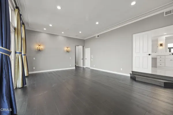 an empty room with wooden floor and mirror
