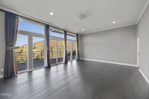 a view of a hallway with wooden floor and stairs