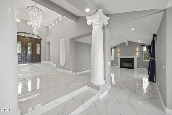 a view of a hallway with chandelier and a chandelier