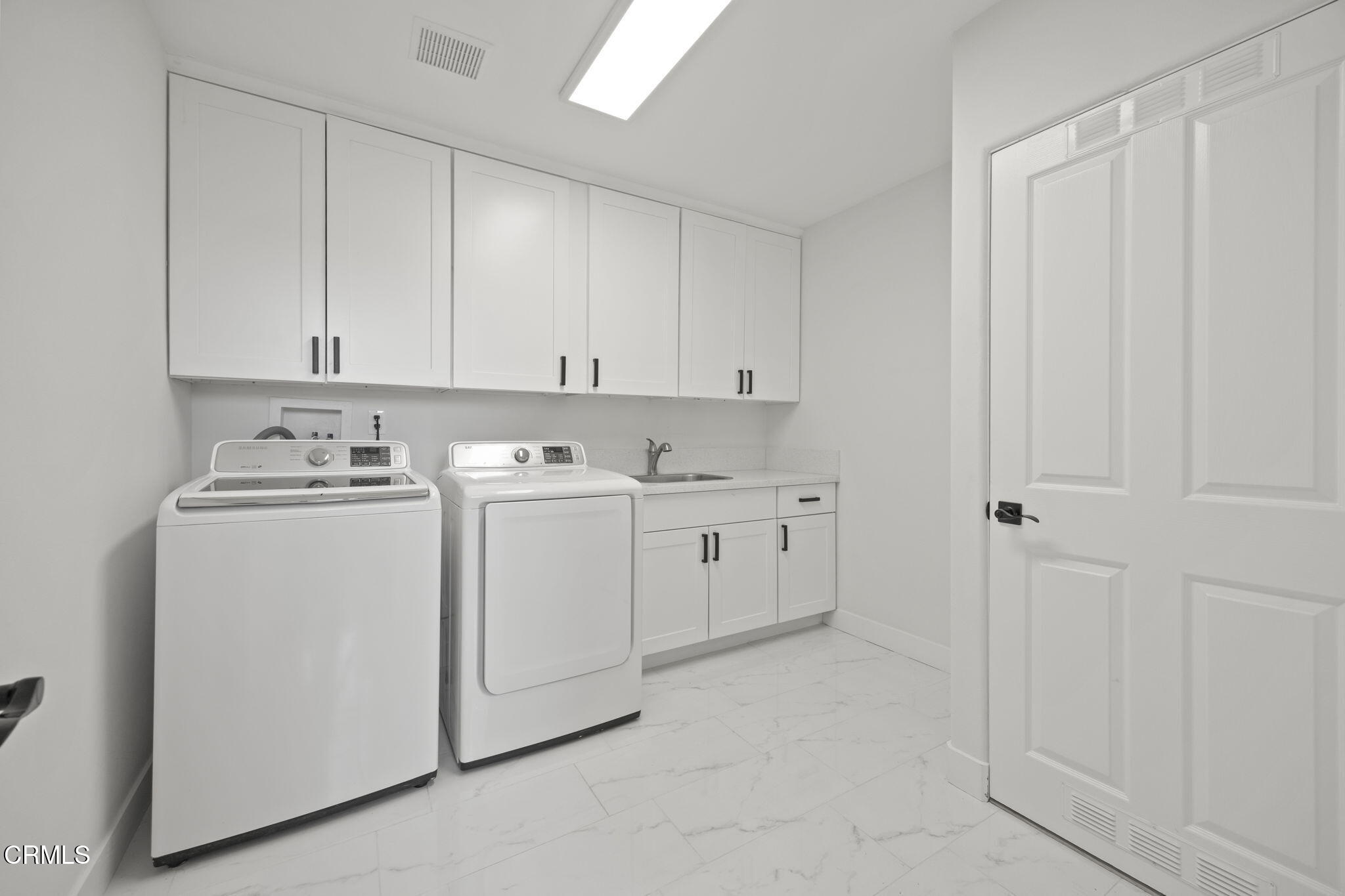 40 Saddlebow Road Bell Canyon, CA 91307 - Photo 56 of 70 a utility room with cabinets washer and dryer