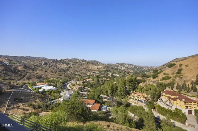 a view of a hallway with wooden floor and a kitchen