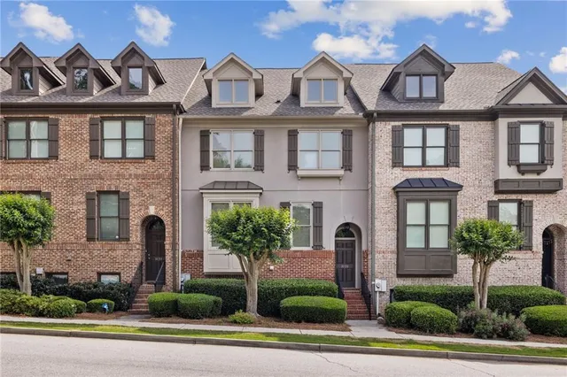 a front view of a house with a yard and potted plants