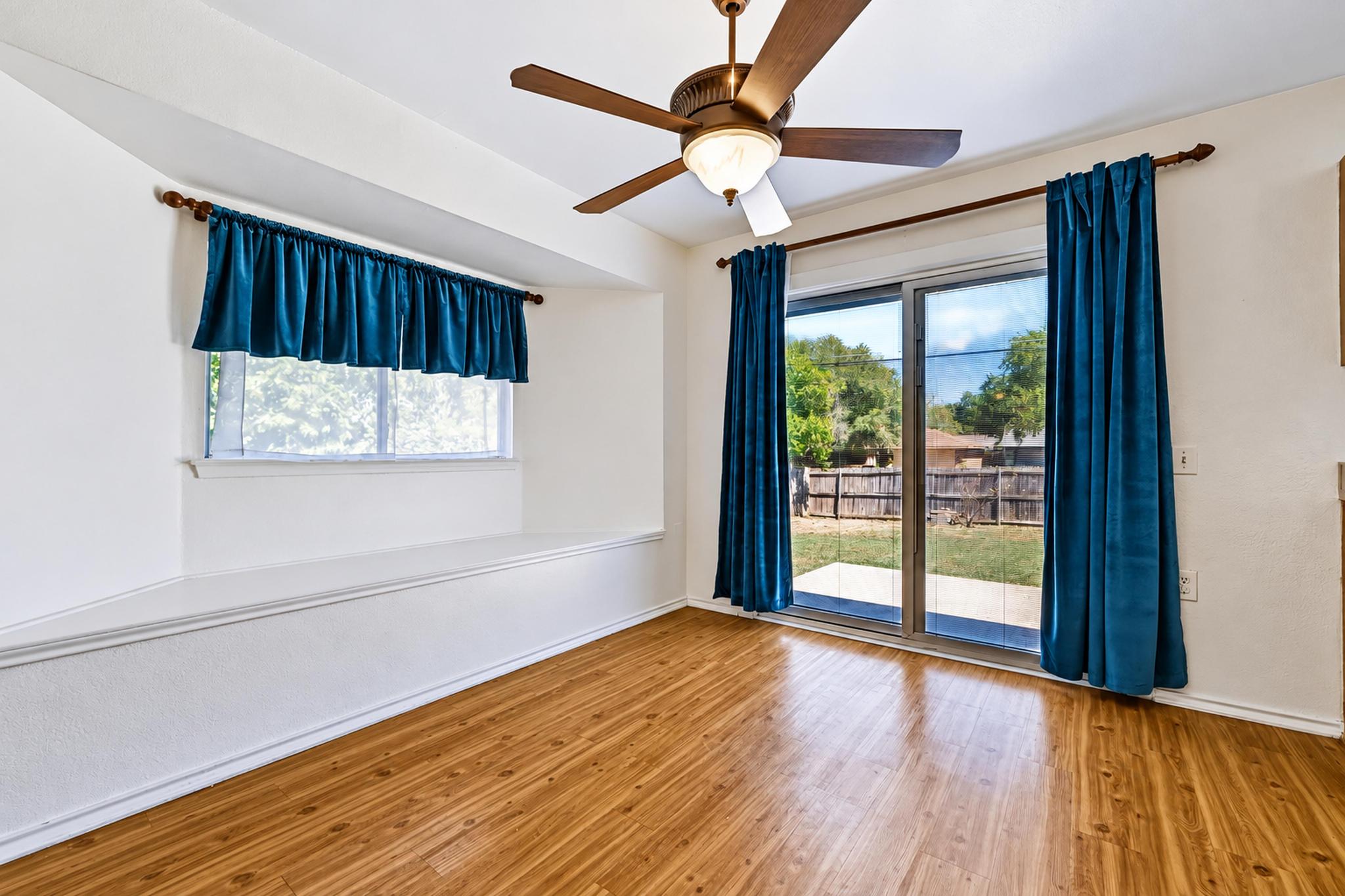 7317 Marble Ridge Drive Austin, TX 78747 - Photo 12 of 30 Rich wood flooring runs throughout this space featuring sliding glass doors and a window bench.