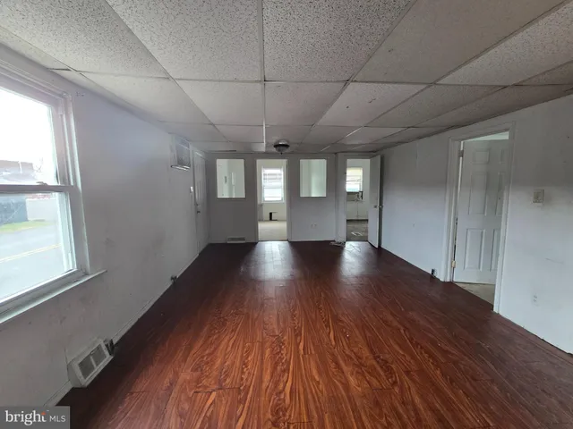 a view of empty room with wooden floor and windows