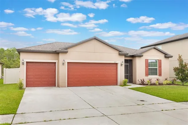 a front view of a house with a garden and garage
