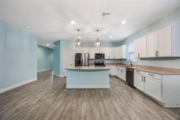 a large kitchen with stainless steel appliances lots of counter top space