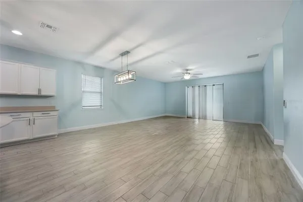 a view of a kitchen with wooden floor and electronic appliances