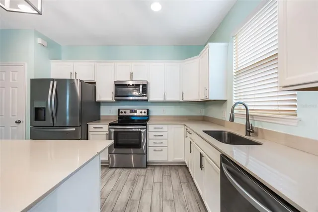 a kitchen with kitchen island white cabinets stainless steel appliances and sink