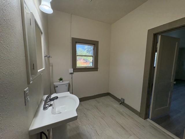 4876 East Williams Spring Road Fort Worth, TX 76135 - Photo 11 of 20 a bathroom with a sink a mirror and wooden floor